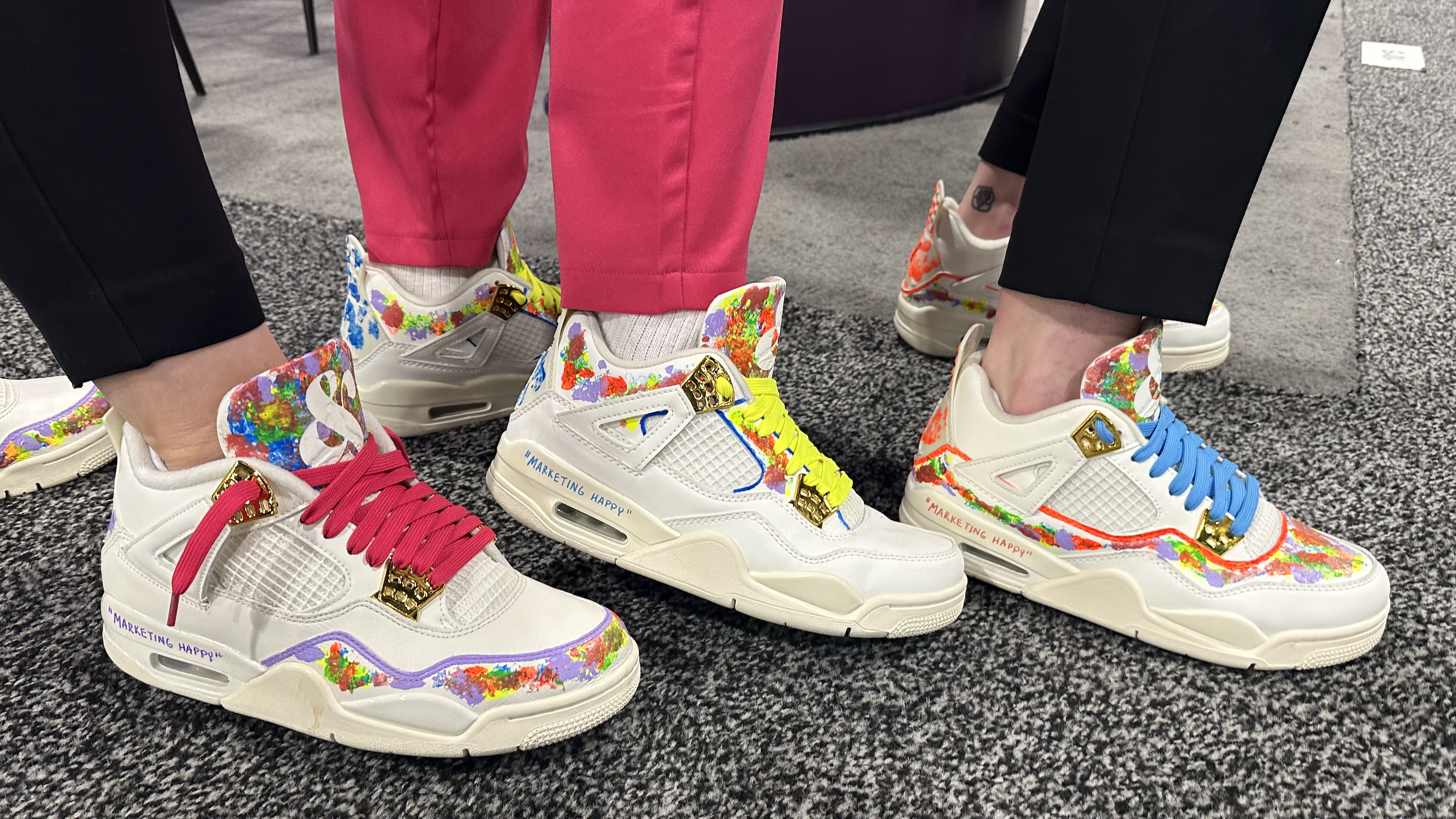 Three pairs of hand-painted Nike shoes by Trent Colquitt are on the feet of Hedy & Hopp team members.